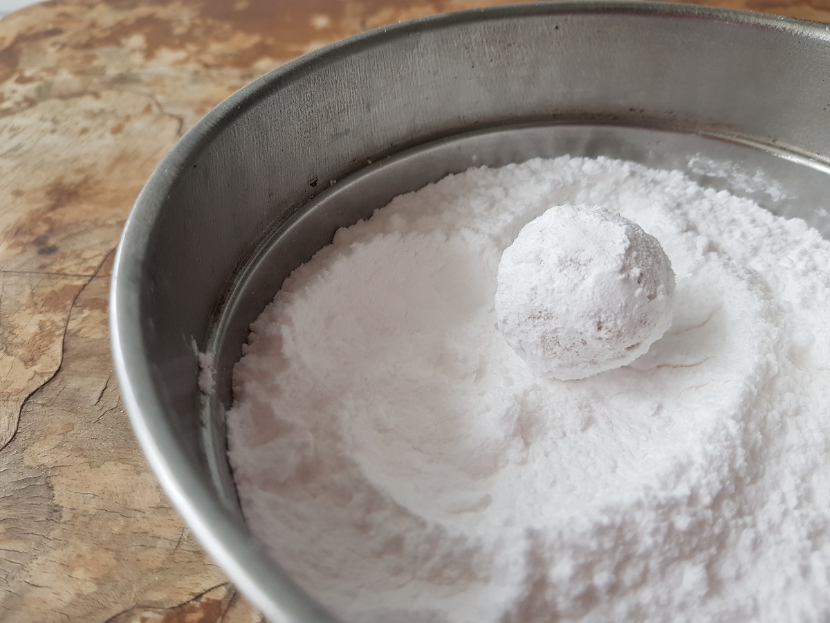 Rotola la pallina di crinkle cookies nello zucchero a velo