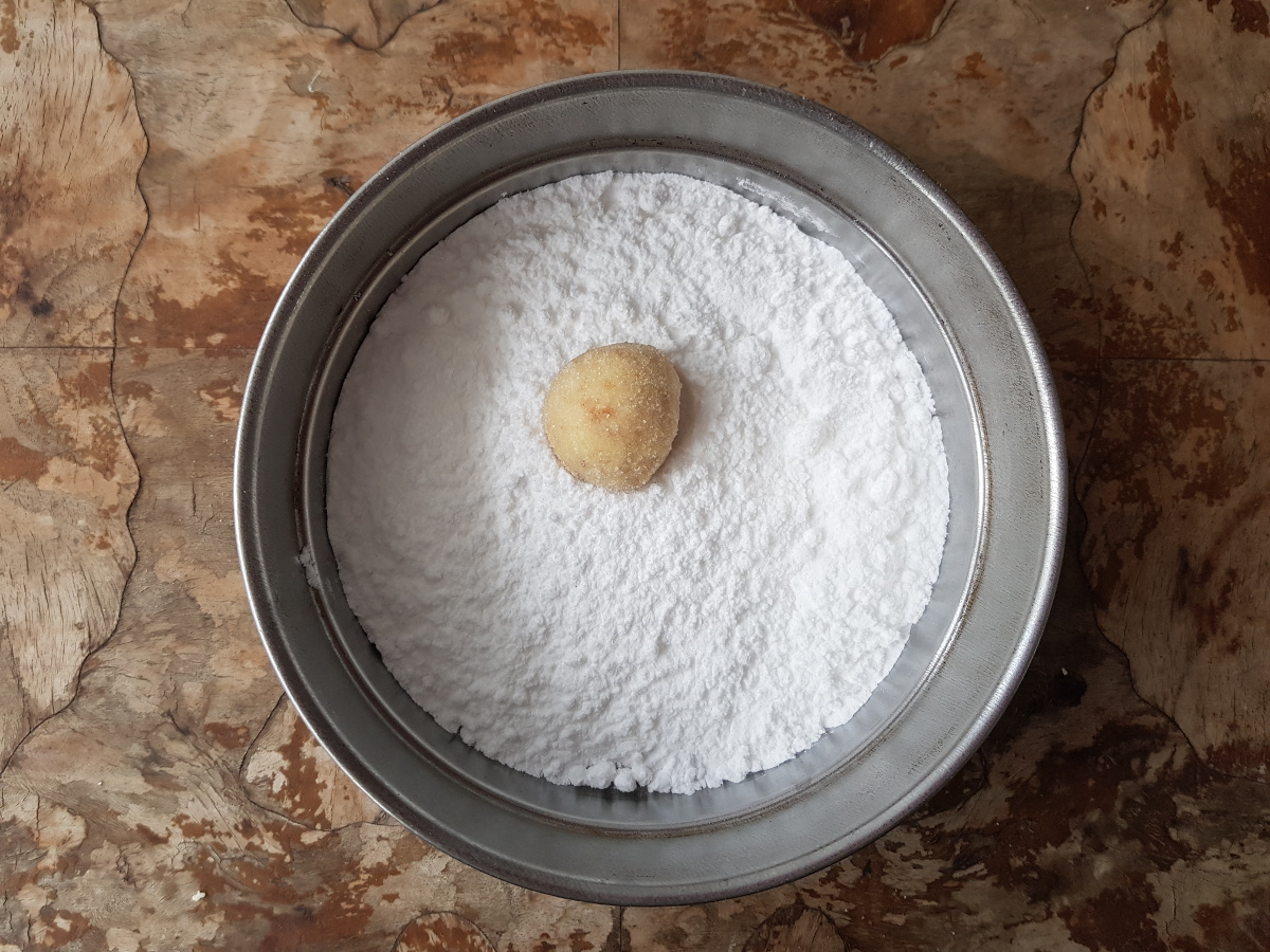 Rotola la pallina di crinkle cookies nello zucchero a velo